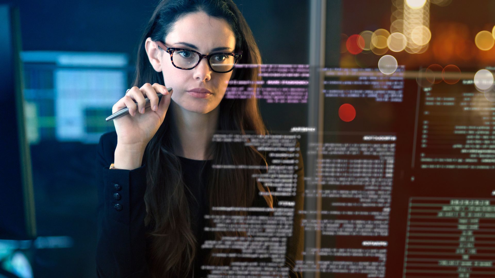 business woman looking at glass screen with computer data and text displayed on it